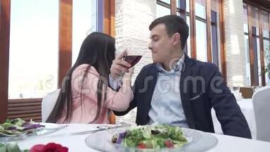 一对情侣在餐厅喝红酒，为兄弟情谊和亲吻慢动作股票视频